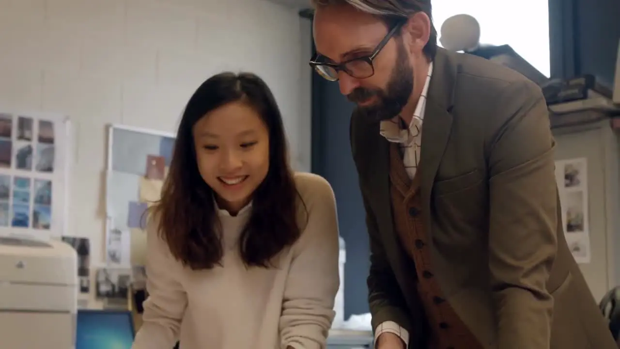 Colleagues interacting with each other at desk 4k