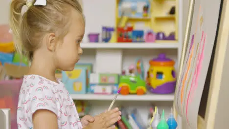 Little girl having fun painting with water colors