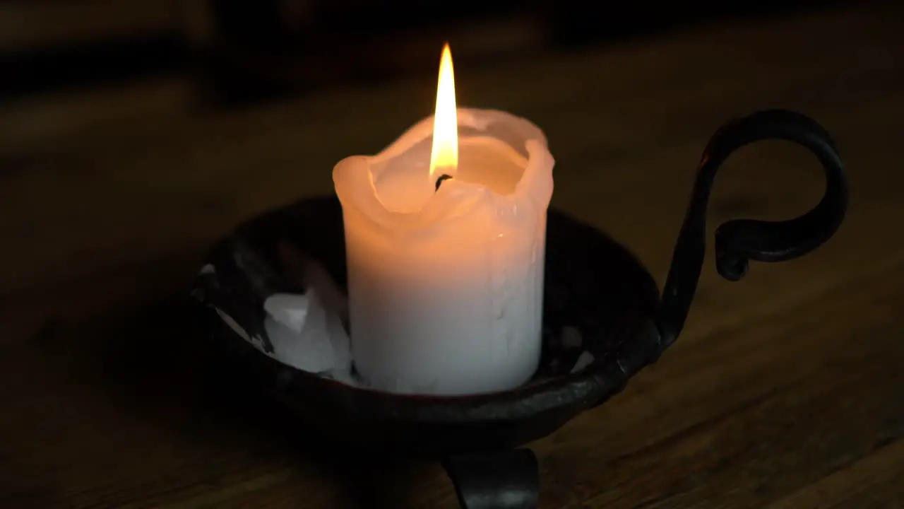 Candle in a candlestick on a wooden table