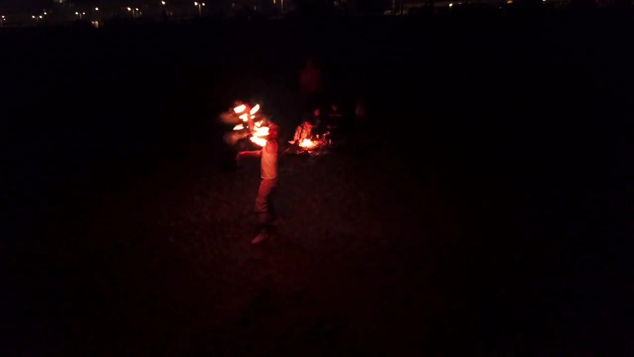 Aerial Drone Shot of Fire dancer dances on a summers night on Brighton Beach England