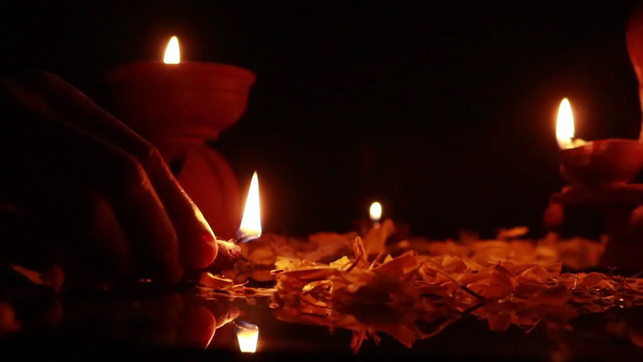 Placing small mud lamps for a festival