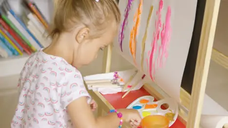 Cute little girl mixing paints for her painting