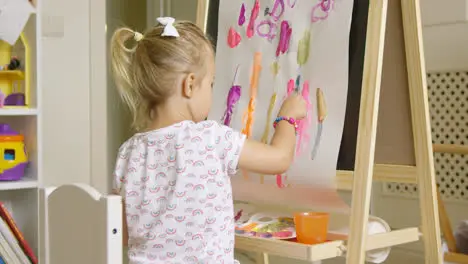 Cute creative little girl artist painting