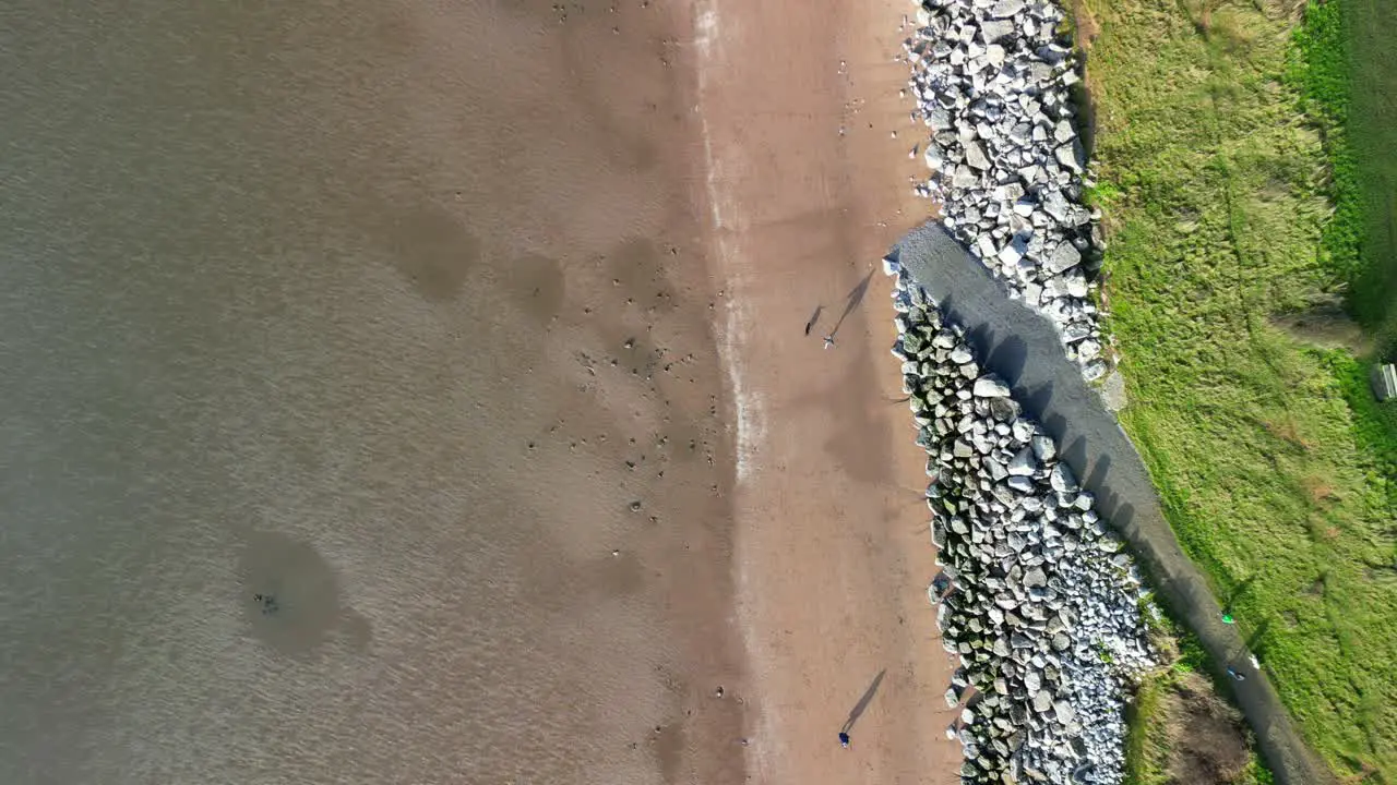 Giant Beach Shadow Walkers by drone on a sunny afternoon Cubbins Green Beach Caldy Wirral UK