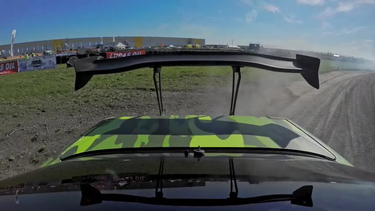 POV shot of a race drifting car with smoking tires and challenge spoiler