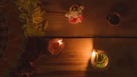 Lit Diya Lamps On Table Decorated For Festival Of Diwali With Statue Of Ganesh 1