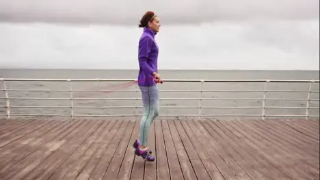 High pace video Young woman working out on the jump rope Outdoor sports Girl jumping on a skipping rope by the sea