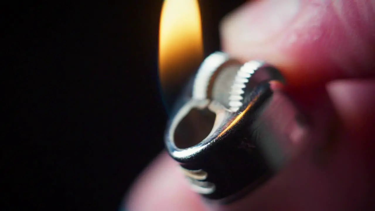 Super slow motion macro shot of a lighter being lit in the dark with a flame coming out