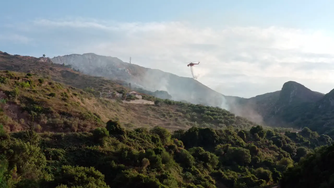 Firefighting Helicopter Drops Water on Burning Forest