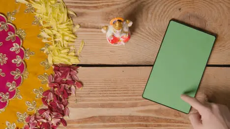 Person Using Green Screen Digital Tablet On Table Decorated For Festival Of Diwali