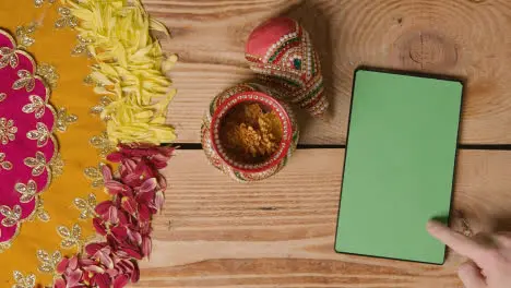 Overhead Of Traditional Coconut Pots On Table Decorated For Celebrating Festival Of Diwali With Digital Tablet