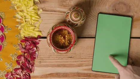 Overhead Of Traditional Coconut Pots On Table Decorated For Celebrating Festival Of Diwali With Digital Tablet 1