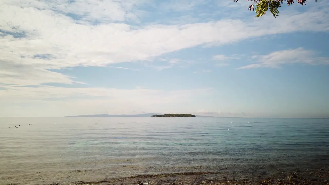 Jib shot of beach shore with single island in background