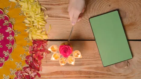 Person Holding Five Wick Lamp On Table With Green Screen Digital Tablet In Festival Of Diwali