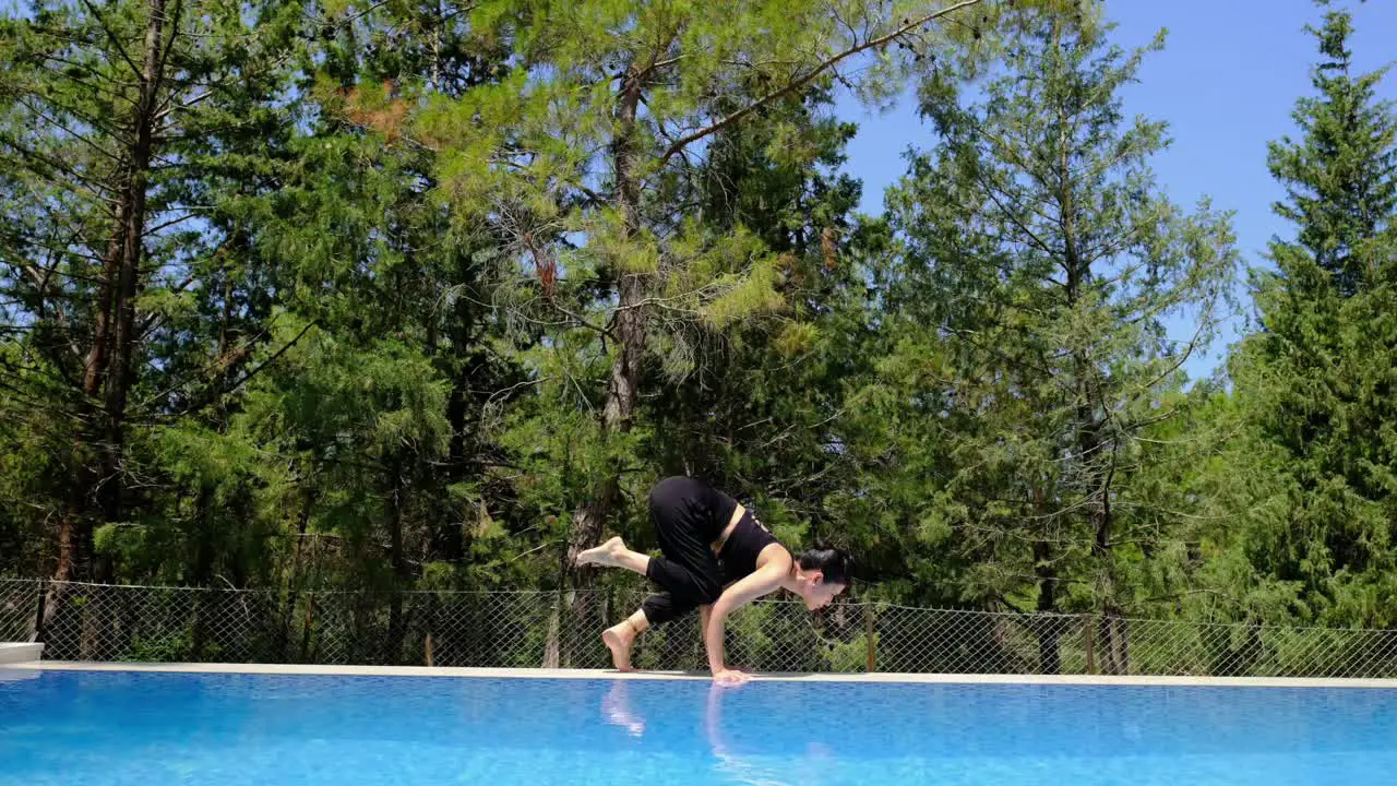 woman does yoga by the pool