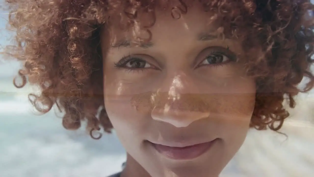 Animation of happy biracial woman face over seascape