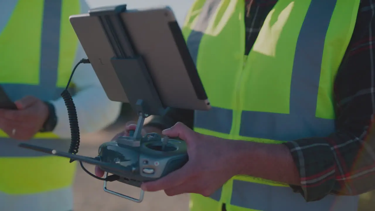 Two construction workers look at tablets