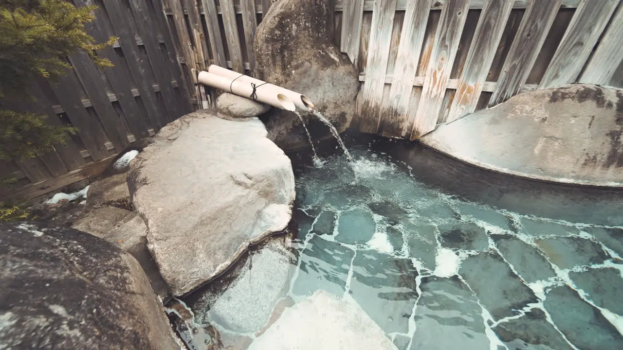 Water Coming Out From Bamboo Pipe Into An Outdoor Onsen In Gifu Japan