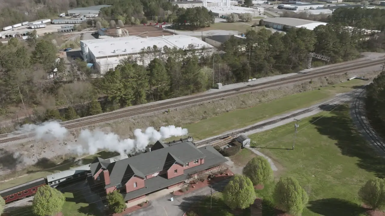 Aerial drone shot of a steam train engine stopping at a train station in Chattanooga TN