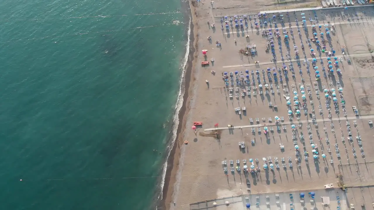 Bird's eye view of a sandy beach with sunbeds and umbrellas