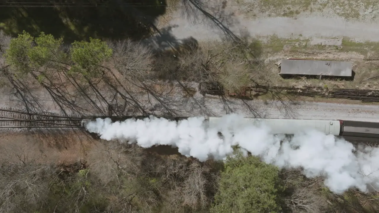 Aerial drone shot static overhead steam train engine moving down the tracks in Chattanooga TN