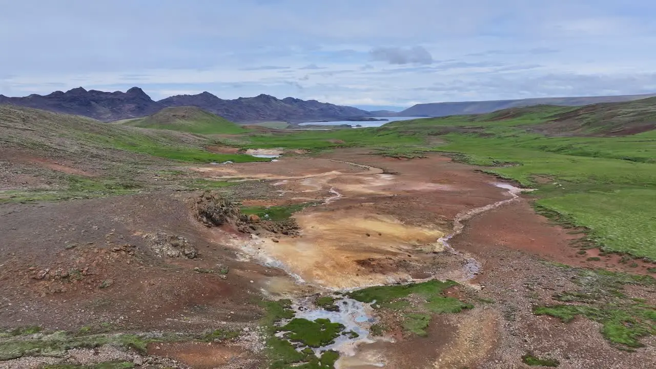 An aerial drone's forward view from Engjahver's steam lake to the nearby Kleifarvatn Lake on the Reykjanes Peninsula in Iceland