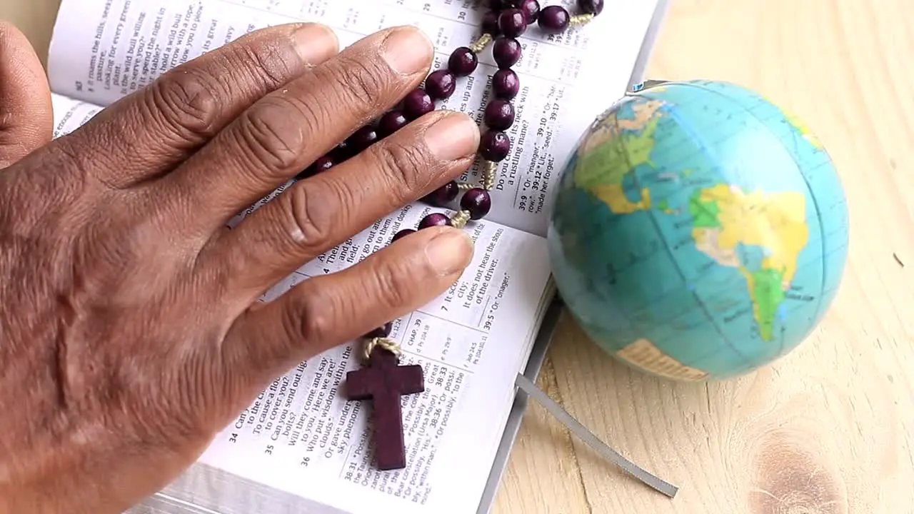 praying to God with hand on bible with cross and globe background with people stock footage