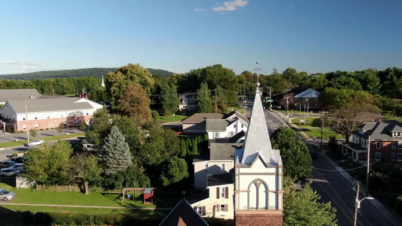 Aerial pull-back reveal shot of old historic church in small town America United States establishing shot of Christianity in USA