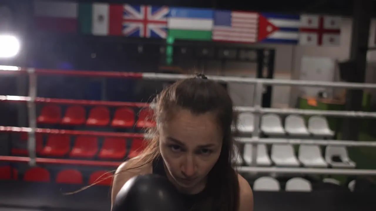 Female Boxer Punching Camera Shadow Boxing During Workout In Dark Gym