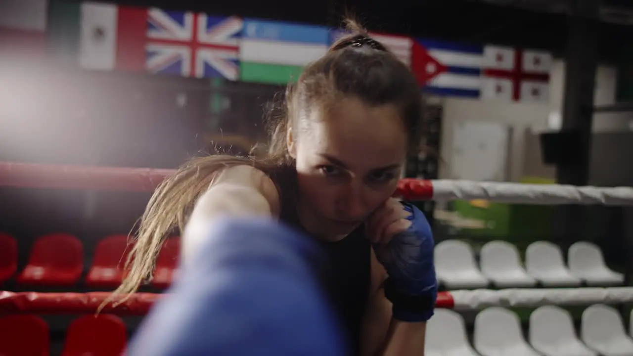 Female Boxer Punching Camera During Training In Bandages