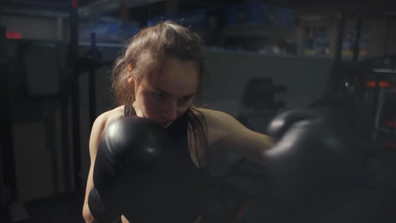 Female Boxer Shaking Camera During Training In Gloves With Bag