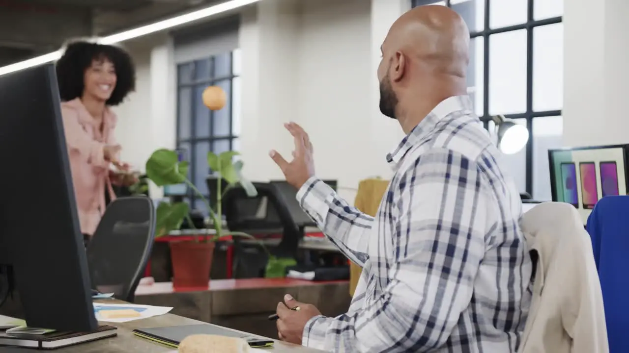 Two happy diverse creative colleagues during lunch in casual office slow motion