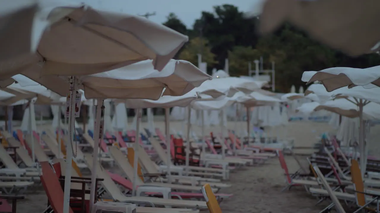 Empty chaise-longues on resort in cloudy windy evening