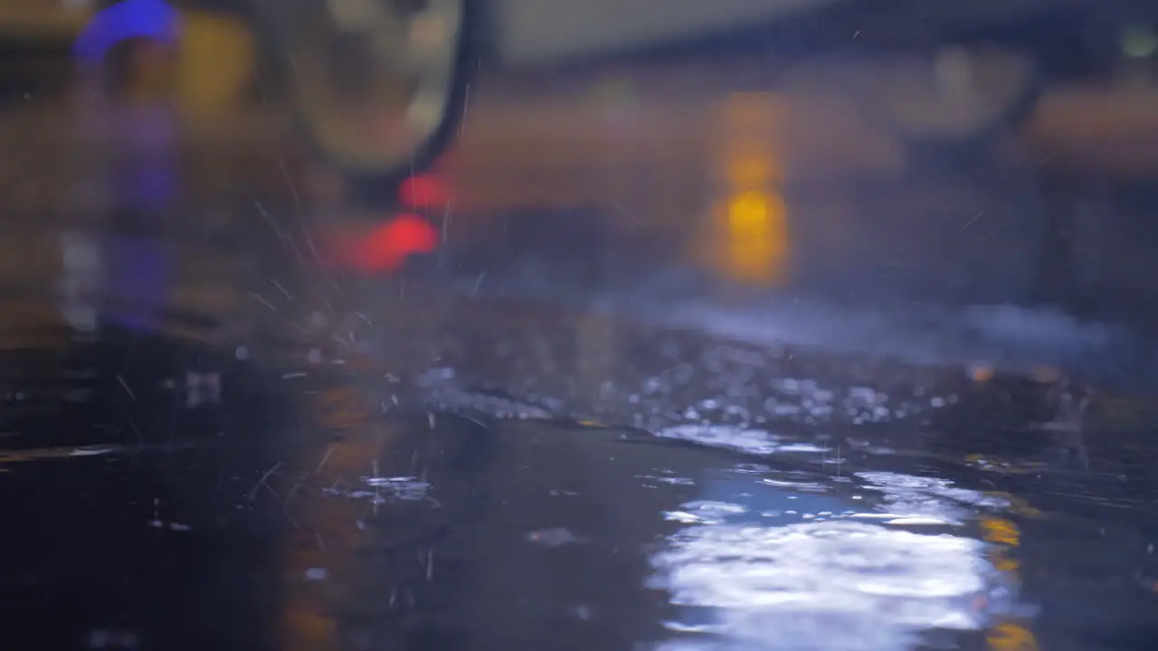 Drizzle and puddles on the asphalt with lights reflection