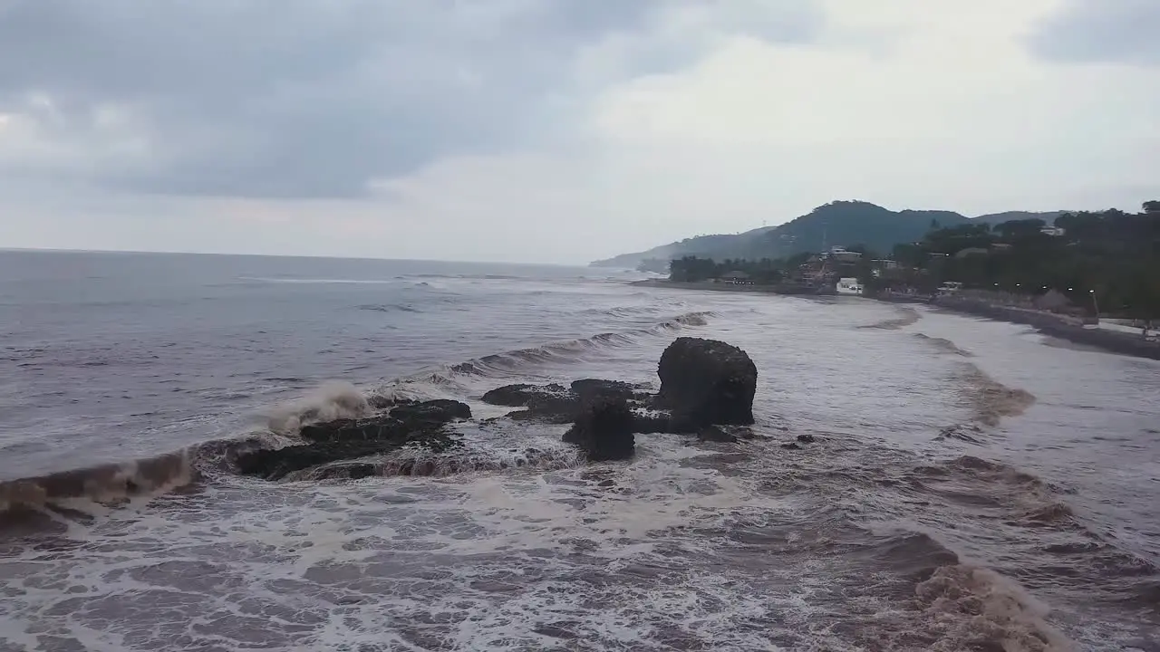 Popular surf spot El Tunco beach in El Salvador during an overcast and cloudy day Aerial footage Orbit shot