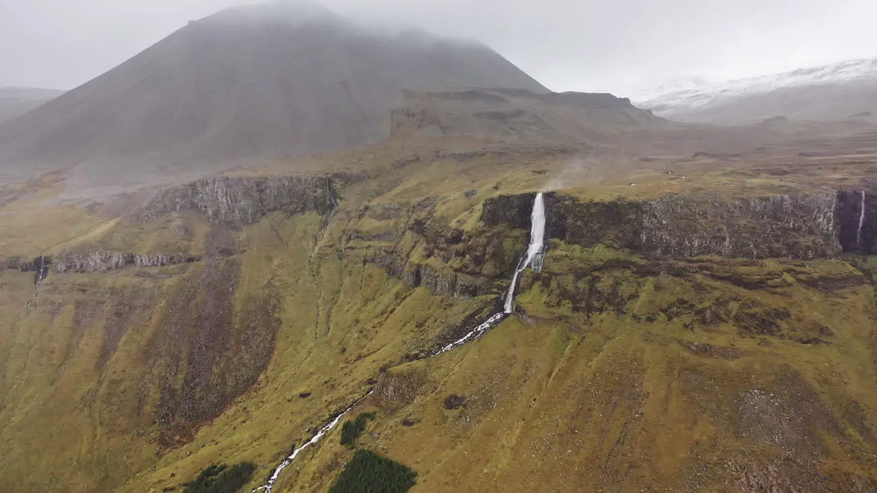 Drone flight towards wind-blown waterfall in Iceland