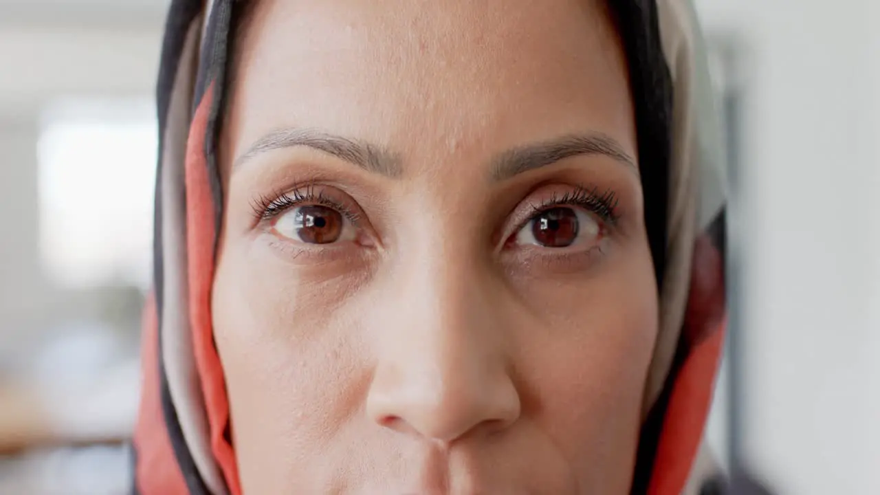 Portrait of happy biracial businesswoman with hijab in office in slow motion