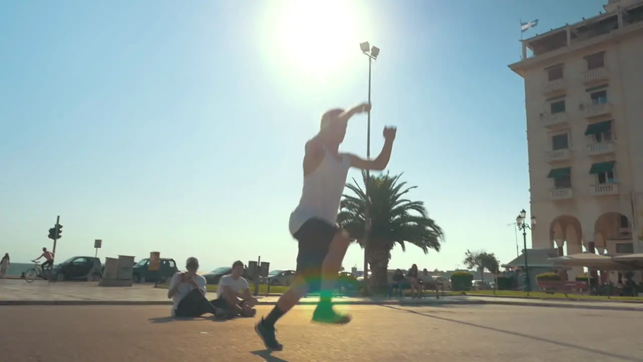 A teenager doing a lot of cart-wheels and jumps in the air outside