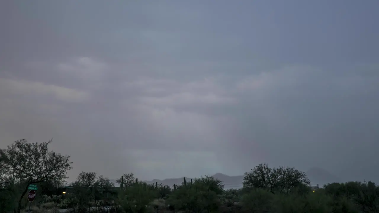 Columns of monsoon rain soaks a desert vista at the end of a summer day