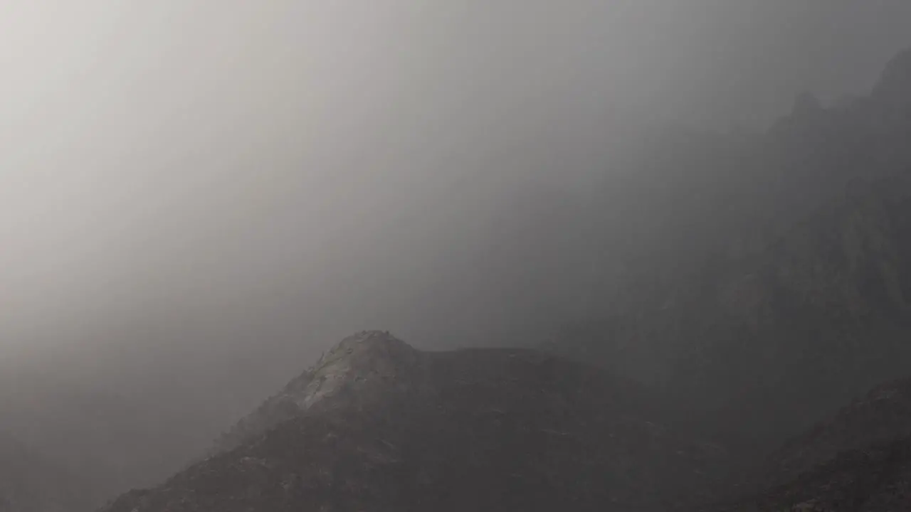 Sheets of monsoon rain come crashing over desert peaks obscuring them from site