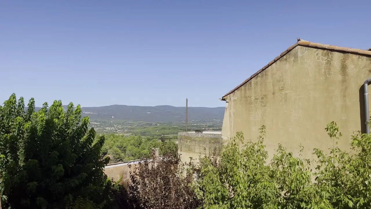 Panning through a small village in France onto a beautiful landscape in good weather