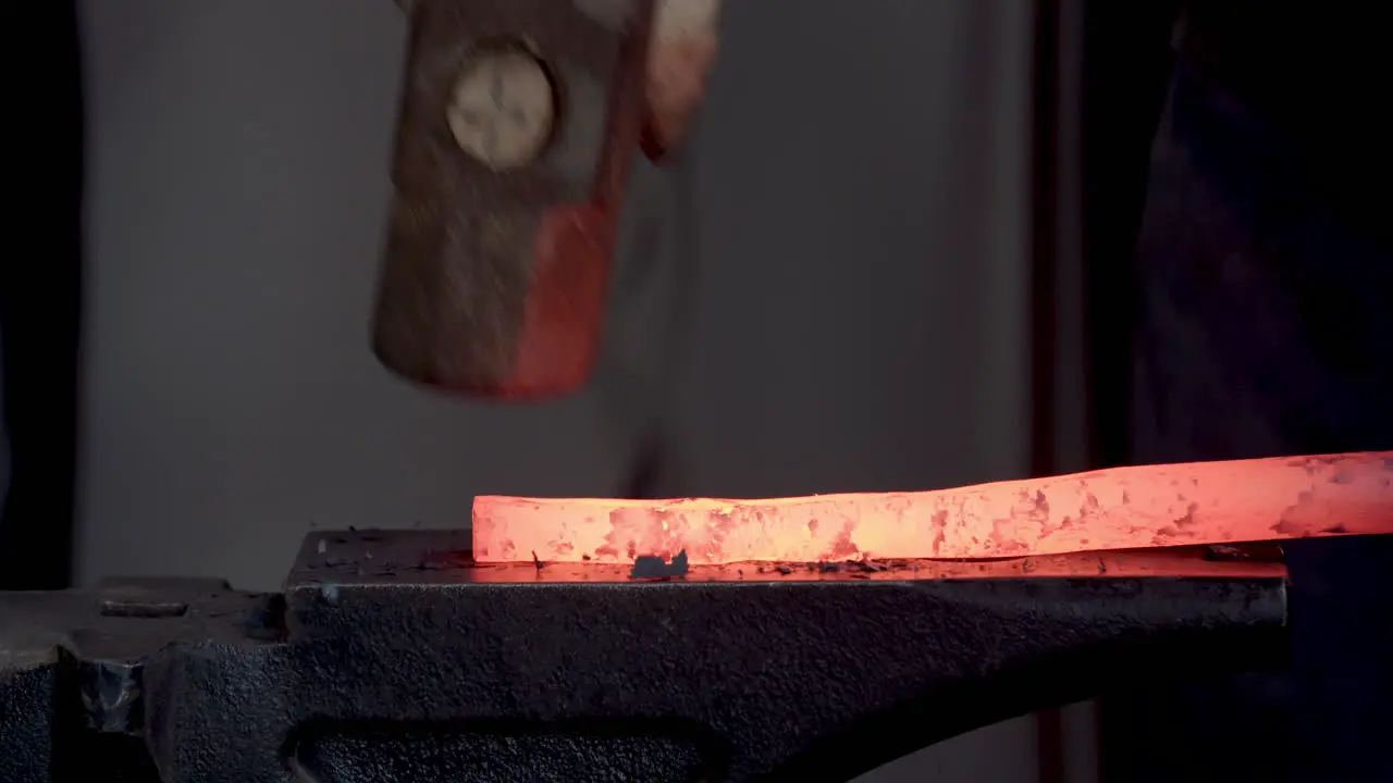 Blacksmith Shaping Red Hot Iron On The Anvil