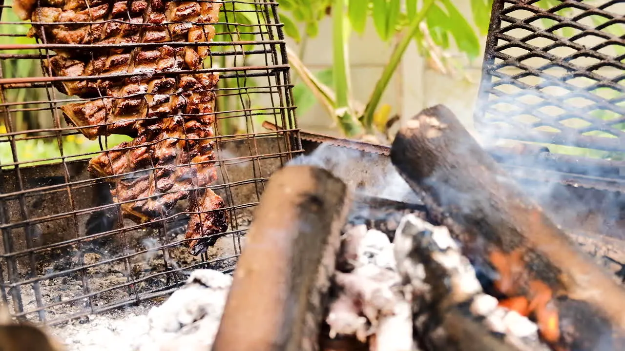 Lamb rack of ribs barbecued on its side next to the fire fat dripping down from heat