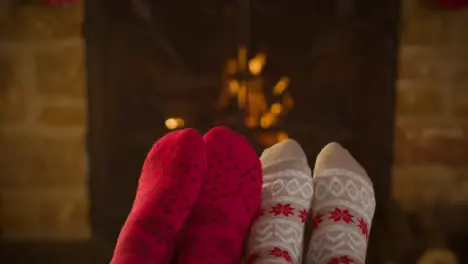 Close Up Shot of Couples Feet In Front of Burning Fireplace