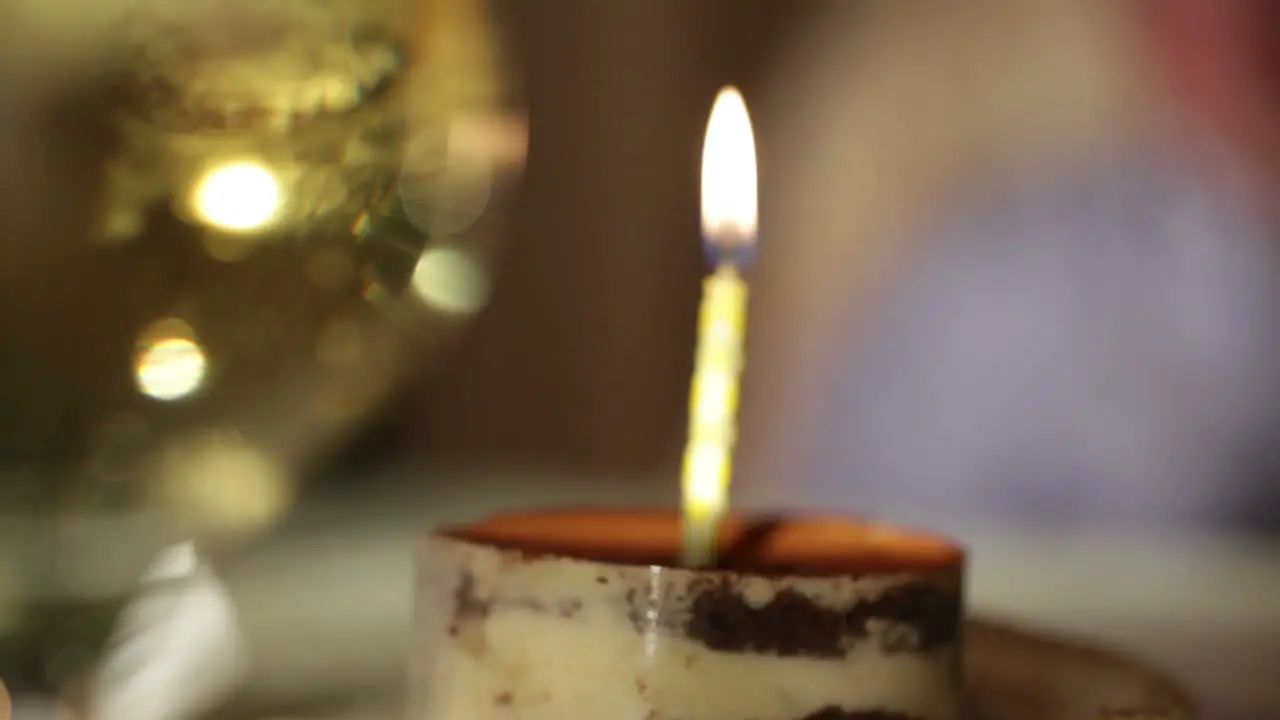 Glass of champagne and candle in the tiramisu cake