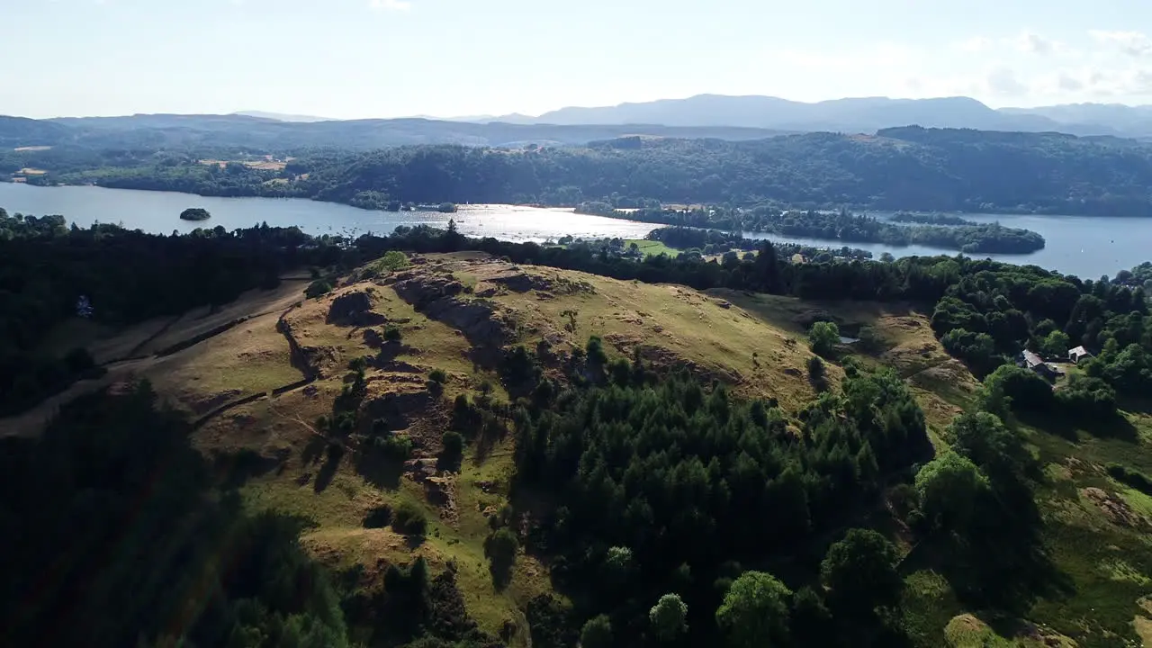 Drone shot of green hills and Lake Windermere in sunlight Lake District UK