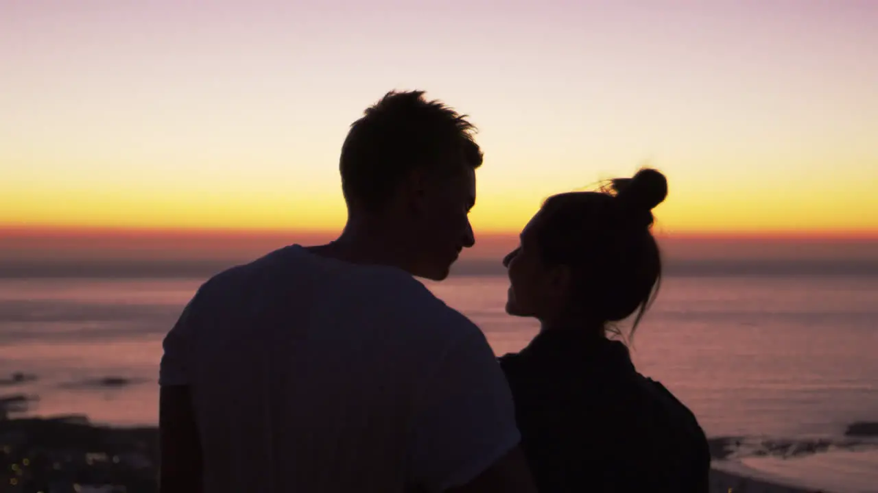 Couple kissing by the sea at sunset silhouette