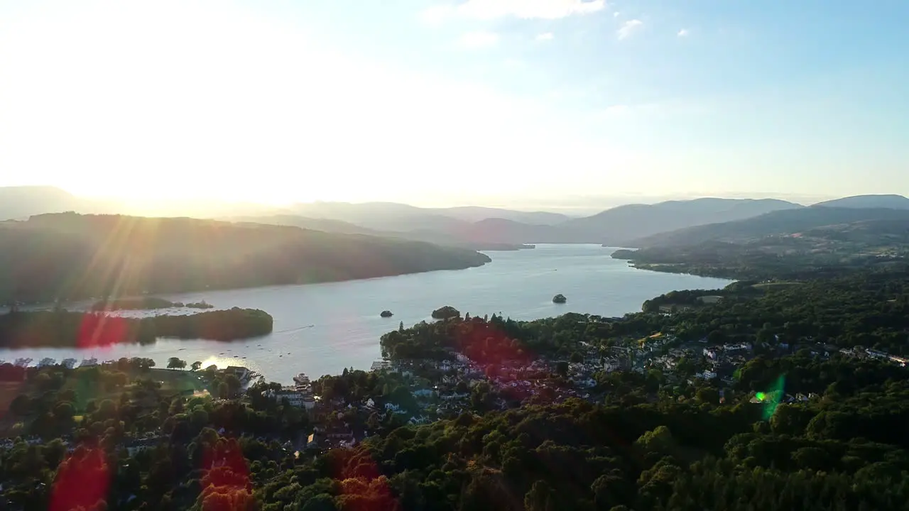 Aerial shot moving back from the houses on the lakeshore and surrounding countryside at Lake Windermere Lake District UK