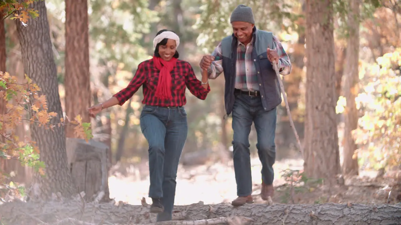 Senior black couple hiking in a forest front view