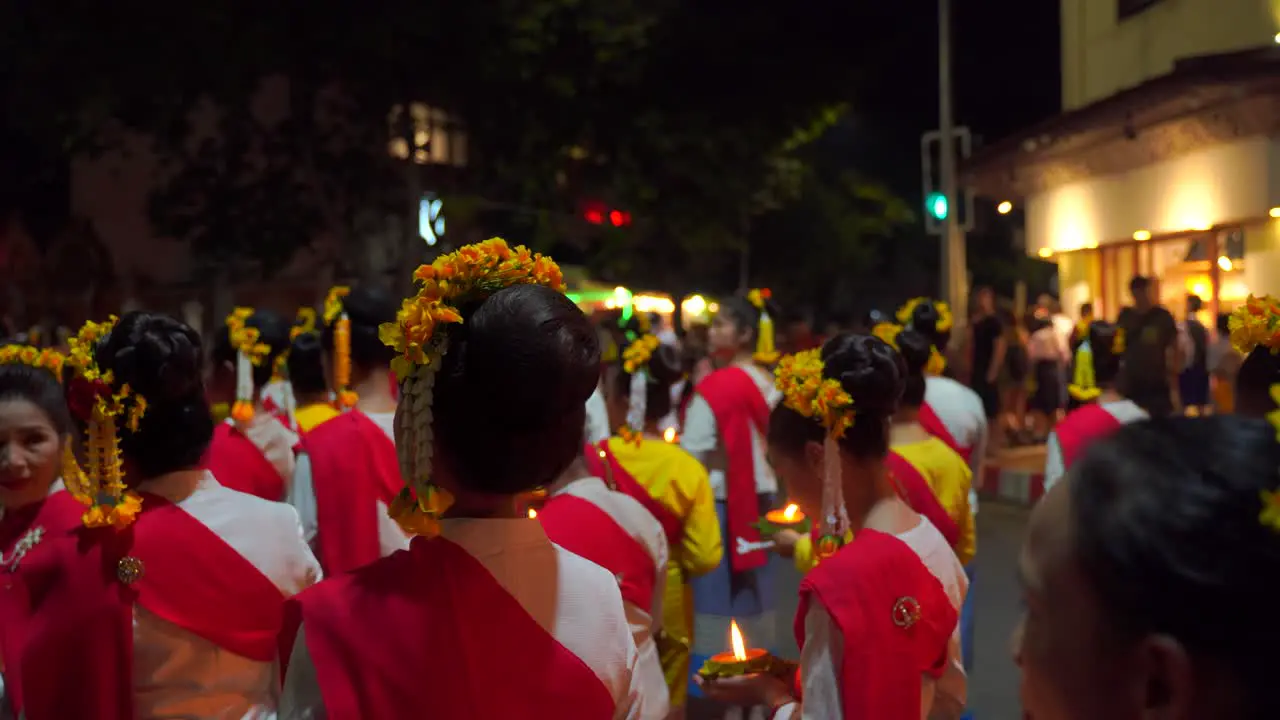 Women at traditional Yi Peng parade in Chiang Mai Thailand at night